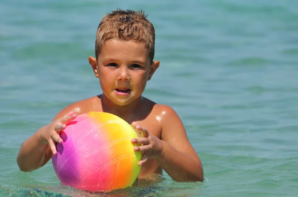 Menino na praia brincando com bola — Fotografia de Stock