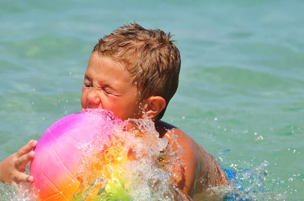 Menino na praia brincando com bola — Fotografia de Stock