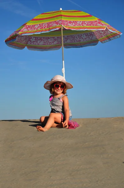 Chicas en la playa de arena bajo un paraguas de playa — Foto de Stock