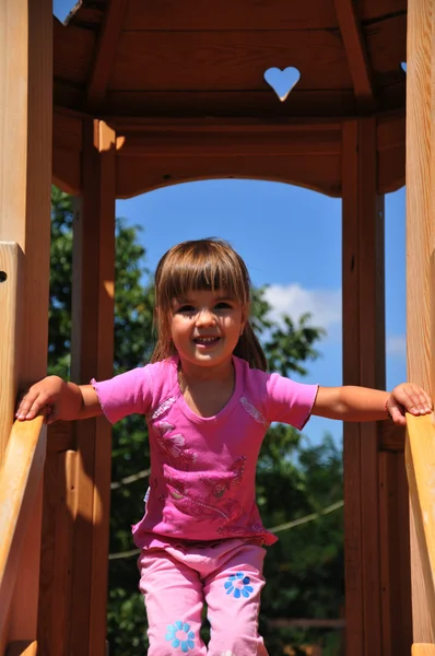 Una hermosa niña en el patio de recreo —  Fotos de Stock