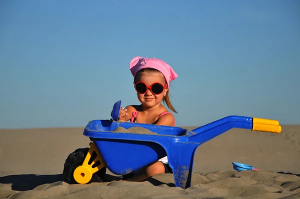 Uma linda menina brincar e saltar na praia — Fotografia de Stock