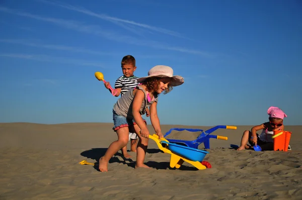 Iki kız ve bir erkek plaj kum üzerinde oynama — Stok fotoğraf