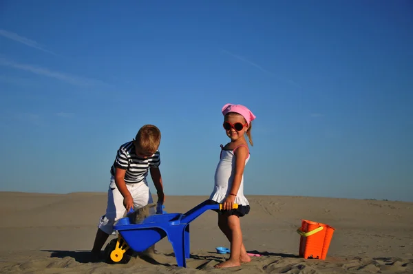 Boy and girl playing on sandy beach — Stock Photo, Image