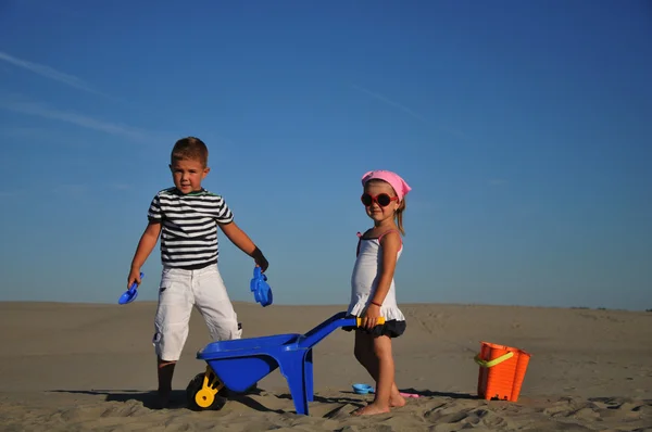 Jongen en meisje spelen op zandstrand — Stockfoto