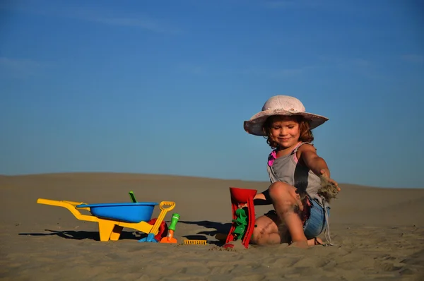 Egy gyönyörű kis lány játszani, és ugrik a strandon — Stock Fotó