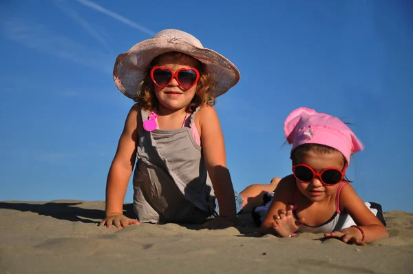 Δύο μικρά κορίτσια που που βρίσκεται στην αμμώδη παραλία — Φωτογραφία Αρχείου