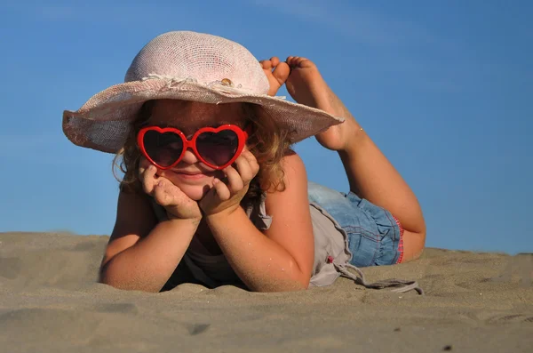 En flicka som ligger på sandstranden — Stockfoto
