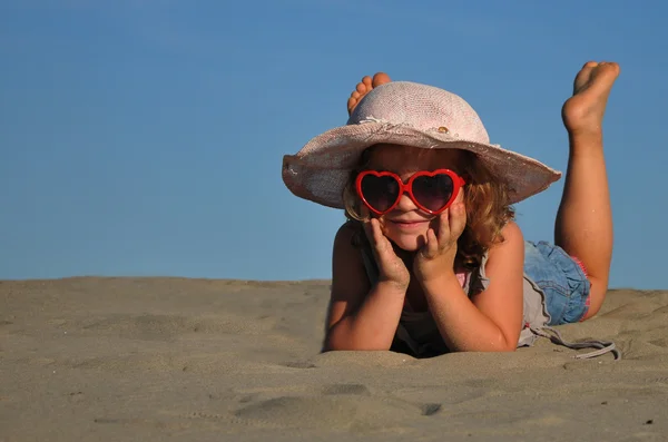 Egy lány a homokos tengerparton fekvő — Stock Fotó