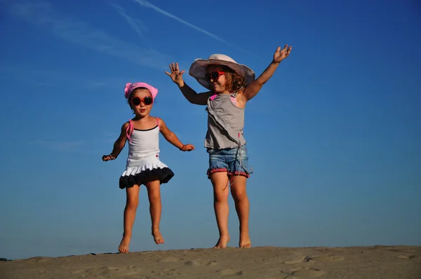Dois feliz menina saltando na praia — Fotografia de Stock