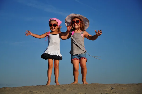 Twee gelukkig meisje springen op het strand — Stockfoto