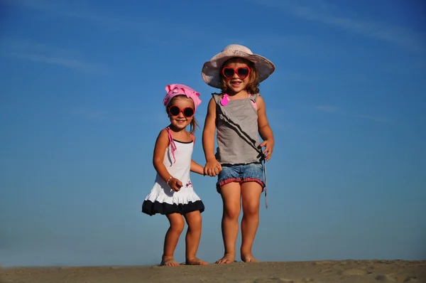Дві щасливі дівчинки стрибають на пляжі — стокове фото