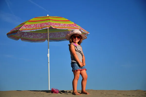 Girls on the beach under a beach umbrella — Stock Photo, Image