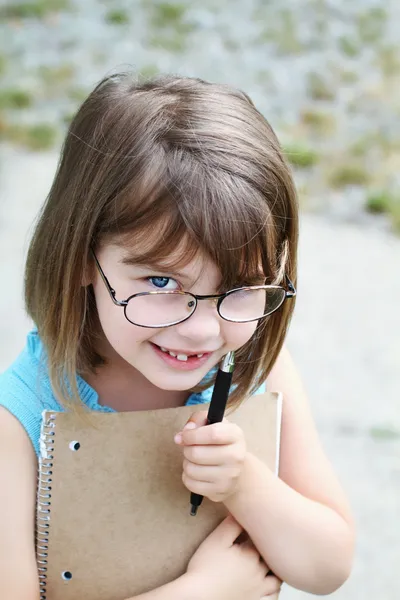 Criança com caneta e livro — Fotografia de Stock