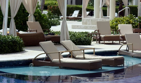 Reclinando cadeiras na piscina de luxo resort tropical — Fotografia de Stock