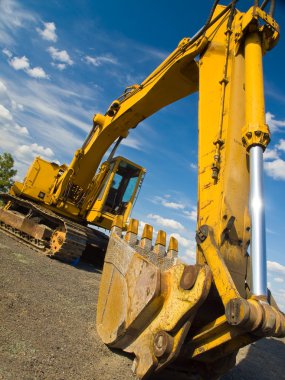 Heavy Duty Construction Equipment Parked at Worksite clipart