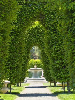 Outdoor Park Archways over a Paved Path on a Sunny Day clipart