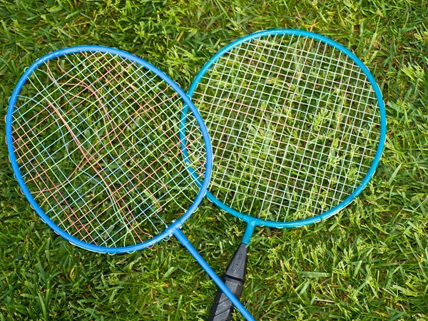 Fechamento de raquetes de badminton em um quintal verde — Fotografia de Stock