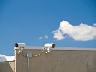 Security Cameras Performing Surveillance on the Side of a Building clipart
