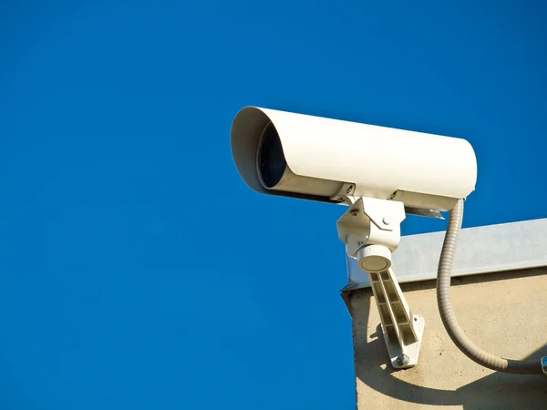 Övervakningskameror som utför övervakning på sidan av en byggnad — Stockfoto