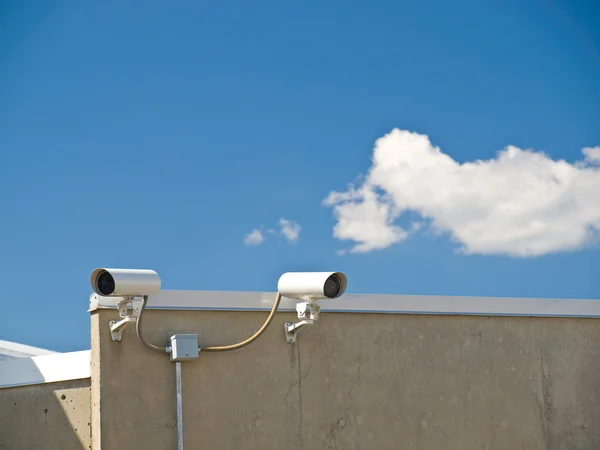 Câmeras de segurança realizando vigilância no lado de um edifício — Fotografia de Stock