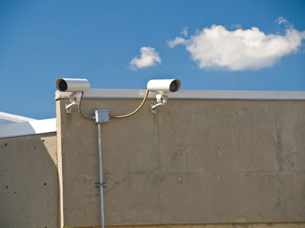 Güvenlik kameraları gözetim bir binanın yan tarafında gerçekleştirme — Stok fotoğraf