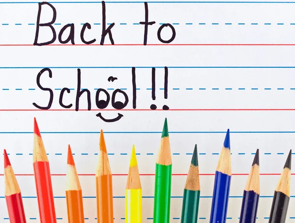 Tillbaka till skolan skrivet en fodrad torr styrelse med färgpennor — Stockfoto