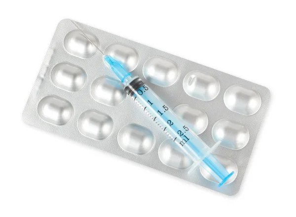 Blister com comprimidos e seringa isolados em branco — Fotografia de Stock