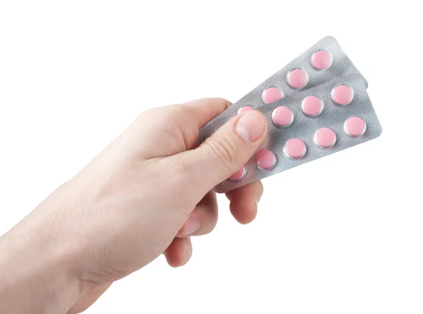 Розовые таблетки в руке изолированы на белом — стоковое фото