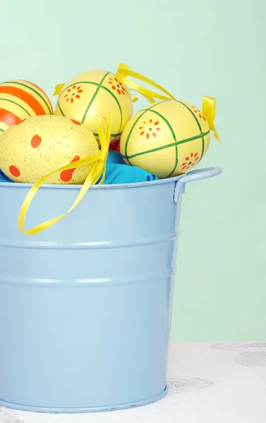 Colorful easter eggs in a blue pail — Stock Photo, Image