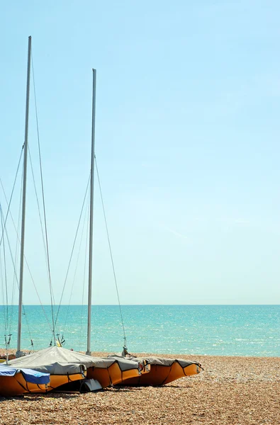 Lagrade segelbåtar på stranden — Stockfoto