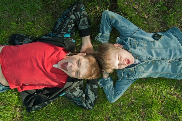 Crianças deitadas na grama — Fotografia de Stock