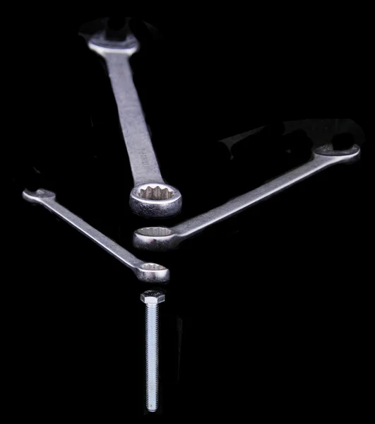 Wrench with a bolt isolated on a black background — Stock Photo, Image