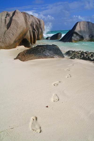 Beach with granite boulders and foot marks — Stock Photo, Image