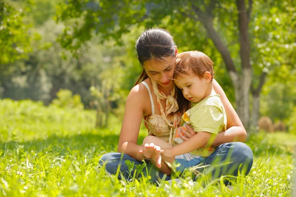 Happy mother and son sitting in a meadow — Stock Photo, Image