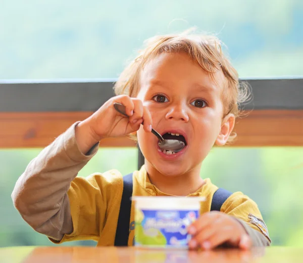 Küçük oğlan yoğurt yiyor. — Stok fotoğraf