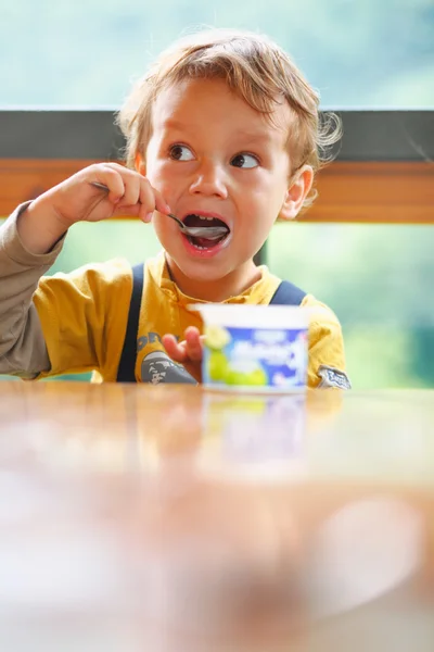 Μικρό αγόρι τρώει γιαούρτι. — Φωτογραφία Αρχείου