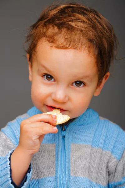 Niño con una galleta — Foto de Stock