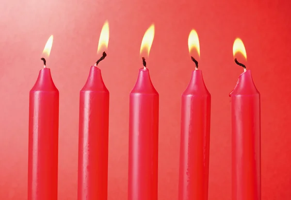 Five Red Candles on red background.