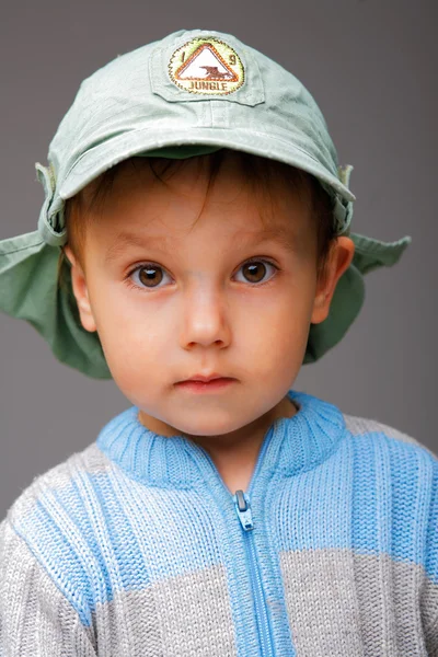 Retrato de primer plano de un niño pequeño con una gorra, serio y atento baño —  Fotos de Stock