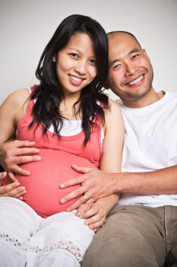 Happy expecting pregnant asian couple