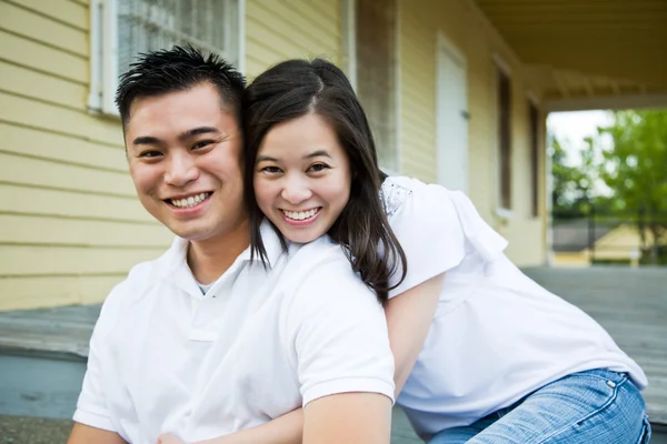 Asian couple in front of their house — Stock Photo, Image