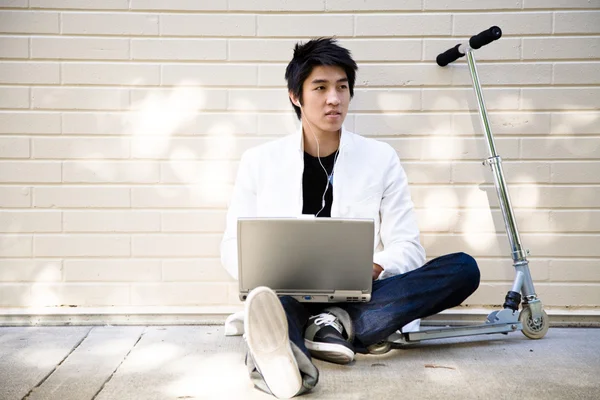 休闲亚洲年轻男子用的笔记本电脑 — 图库照片