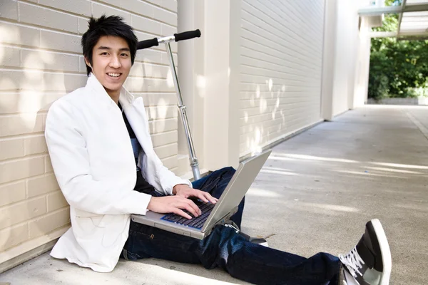Jovem casual asiático masculino com laptop — Fotografia de Stock