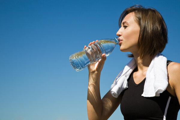Caucasian girl drinking water after exercise