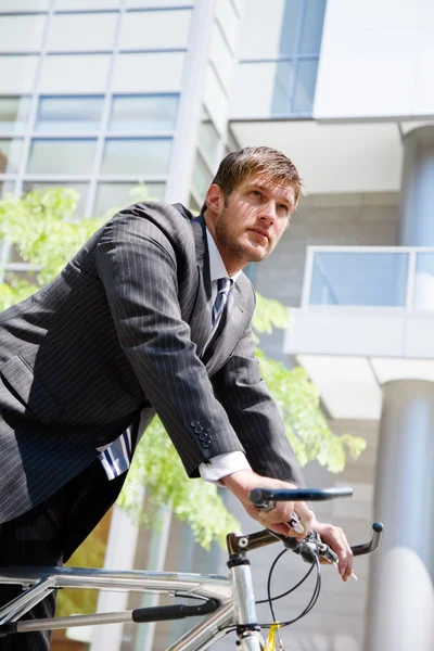 Homem de negócios caucasiano montando uma bicicleta — Fotografia de Stock