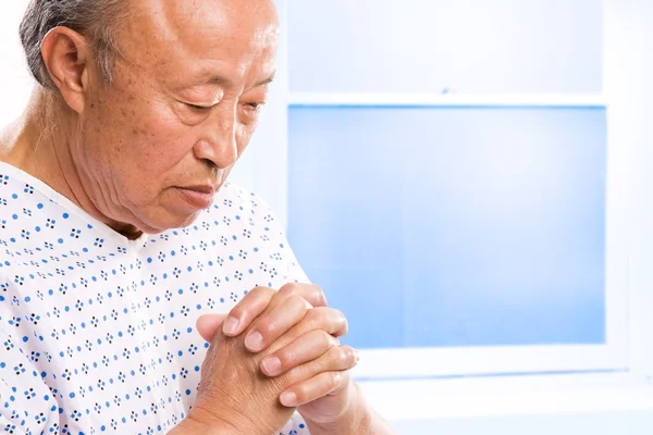Rukoilee vanhempi aasialainen sairaalassa — kuvapankkivalokuva