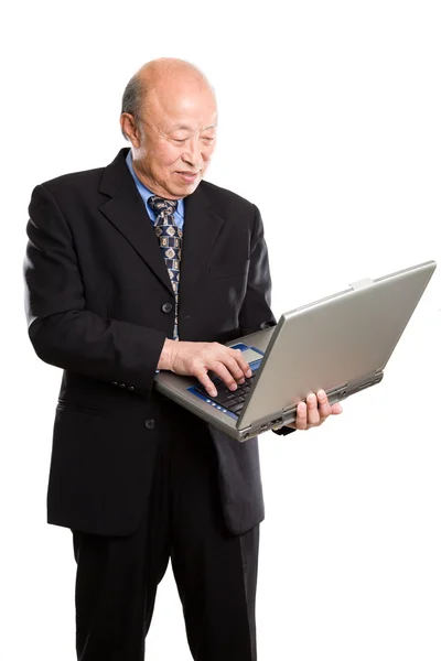 Старший азиатский бизнесмен и ноутбук — стоковое фото