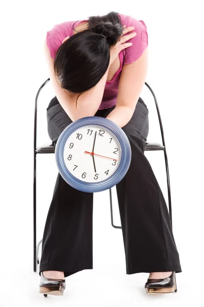Mujer de negocios cansada sosteniendo un reloj — Foto de Stock