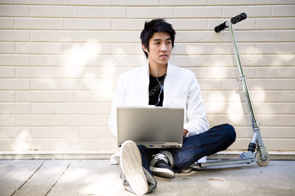 Young casual asian man with laptop