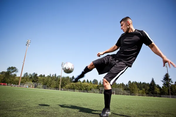 Spansktalande fotboll eller fotboll spelare som sparkar en boll — Stockfoto